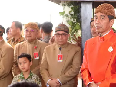Presiden Joko Widodo (Jokowi) bersiap melakukan pemasangan Bleketepe pernikahan Kahiyang Ayu dan Bobby Nasution di kediamannya Jalan Kutai Utara, Solo, Selasa (7/11). Jokowi mengenakan beskap berwarna oranye dan blangkon. (Liputan6.com/Angga Yuniar)