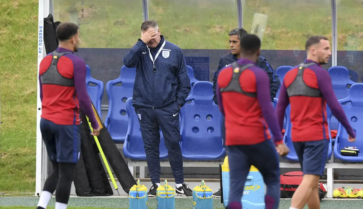 Pelatih Timnas Inggris, Sam Allardyce (tengah) saat enutup wajahnya pada sesi latihan timnas Inggris di St George's Park dekat Burton-Upon-Trent, (3/9/2016). (AFP/Anthony Devlin) 