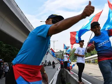 Pendukung Pakatan Harapan memadati jalan menuju Istana Negara menjelang pelantikan Mahathir Mohamad sebagai Perdana Menteri Malaysia di Kuala Lumpur, Kamis (10/5). Mahathir akan menjadi perdana menteri ketujuh Negeri Jiran. (AFP/Manan VATSYAYANA)