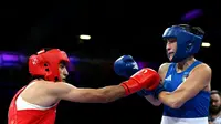 Petinju Aljazair, Imane Khelif (kiri), memukul petinju Italia, Angela Carini, pada pertarungan kelas 66 kg wanita di North Paris Arena, Villepinte, Kamis (1/8/2024). (AFP/Mohd Rasfan)