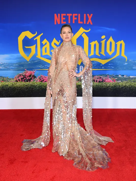 Kate Hudson berpose di karpet merah saat menghadiri pemutaran perdana "Glass Onion: A Knives Out Mystery" di Academy Museum of Motion Pictures  di Los Angeles, California pada 14 November 2022. Kate tampil memukau dalam gaun over-the-top berwarna sampanye, yang menampilkan turtleneck dan lengan panjang. (Charley Gallay/Getty Images for Netflix/AFP)