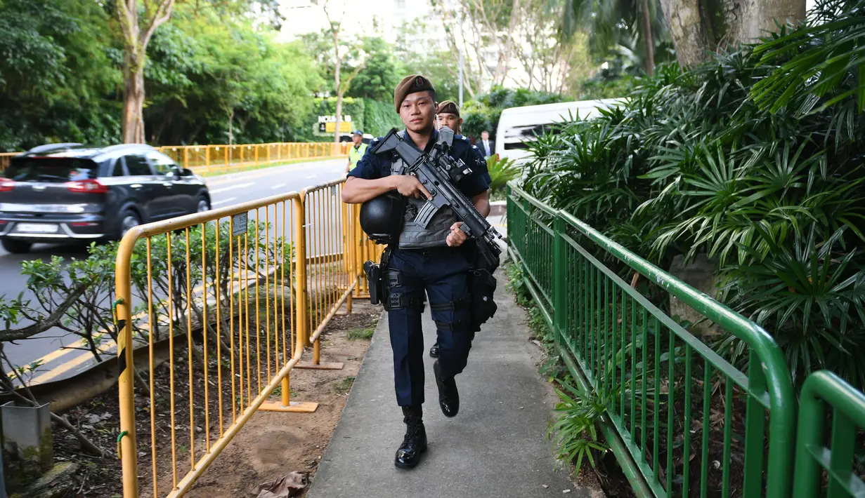 Pasukan Gurkha saat berpatroli di luar Hotel Shangri-La, Singapura, Minggu (10/6). Kontingen Gurkha adalah departemen khusus di bawah naungan Kepolisian Singapura yang beranggotakan pasukan berkewarganegaraan Nepal. (Ted ALJIBE/AFP)