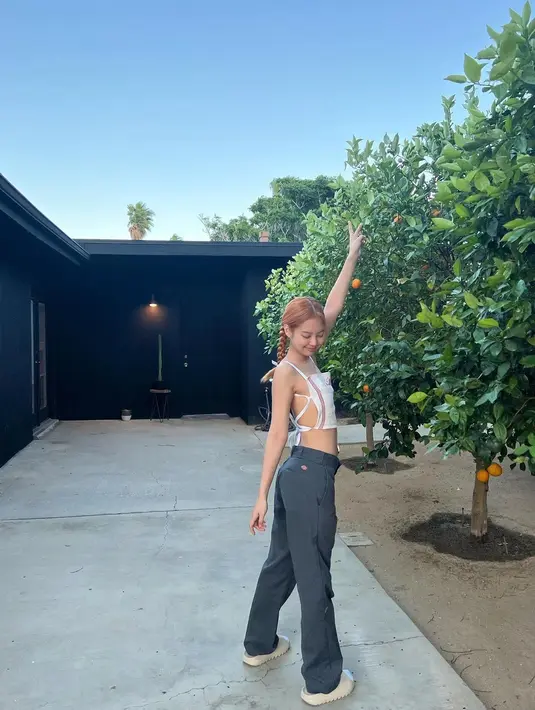 <p>Berpose dengan rambut yang dikepang dua, Jennie terlihat riang mengenakan outfit atasa bertali dengan celana panjang berwarna abu-abu tua, dan sneakers putih. Foto: Instagram.</p>