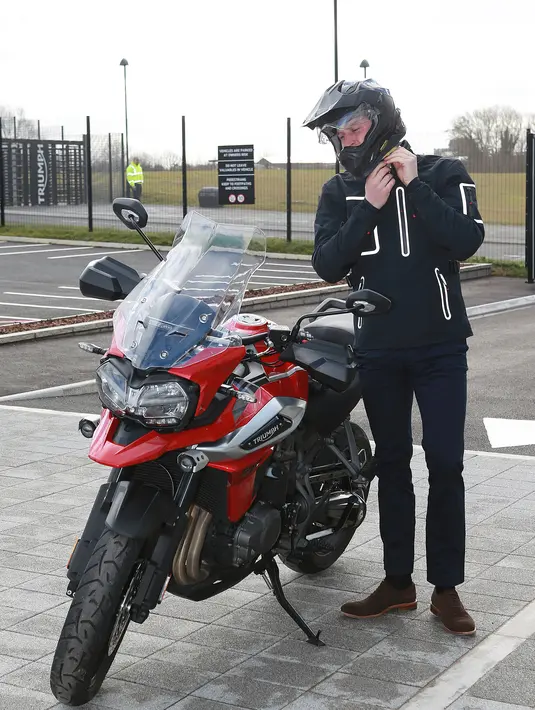 Pangeran William melepas helmnya usai menjajal motor Triumph Tiger 1200 terbaru dalam kunjungannya ke pabrik Triumph Motorcycles di Hinckley, Selasa (20/2). Selain menjajal motor, William juga melihat proses perakitan moge Triumph (Ian Vogler/Pool via AP)