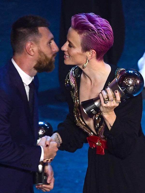 Penyerang Amerika Serikat, Megan Rapinoe memberi selamat kepada pemain terbaik FIFA 2019, Lionel Messi di teater La Scala Milan, Italia utara (23/9/2019). Rapinoe menyabet gelar The Best FIFA Women's Player 2019. (AFP Photo/Marco Bertorello)