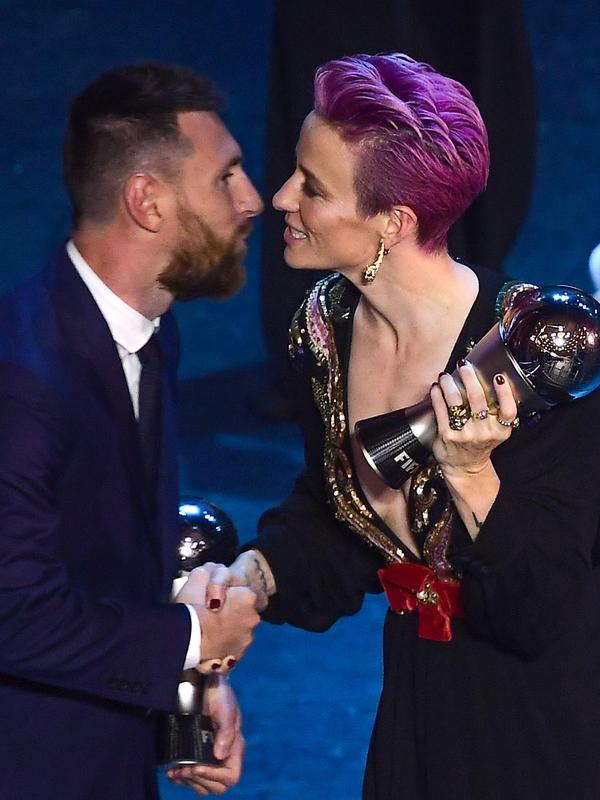 Penyerang Amerika Serikat, Megan Rapinoe memberi selamat kepada pemain terbaik FIFA 2019, Lionel Messi di teater La Scala Milan, Italia utara (23/9/2019). Rapinoe menyabet gelar The Best FIFA Women's Player 2019. (AFP Photo/Marco Bertorello)