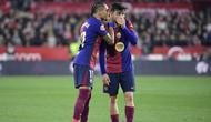 Pemain depan Barcelona asal Brasil #11, Raphinha, berbicara dengan gelandang Barcelona asal Spanyol #08, Pedri (Kanan), selama pertandingan liga Spanyol antara Sevilla FC dan FC Barcelona di Stadion Ramon Sanchez Pizjuan di Seville, Senin dini hari WIB (9-2-2025). (CRISTINA QUICLER/AFP)