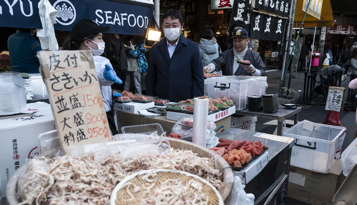 Vendor menjual makanan laut segar dan kering di area "pasar ikan luar" Tsukiji di Tokyo pada 28 Desember 2022. Menjelang liburan Tahun Bar, turis asing dan penduduk lokal berkunjung  ke pasar itu untuk menikmati hidangan bermacam makanan laut. (AFP/Richard A. Brooks)