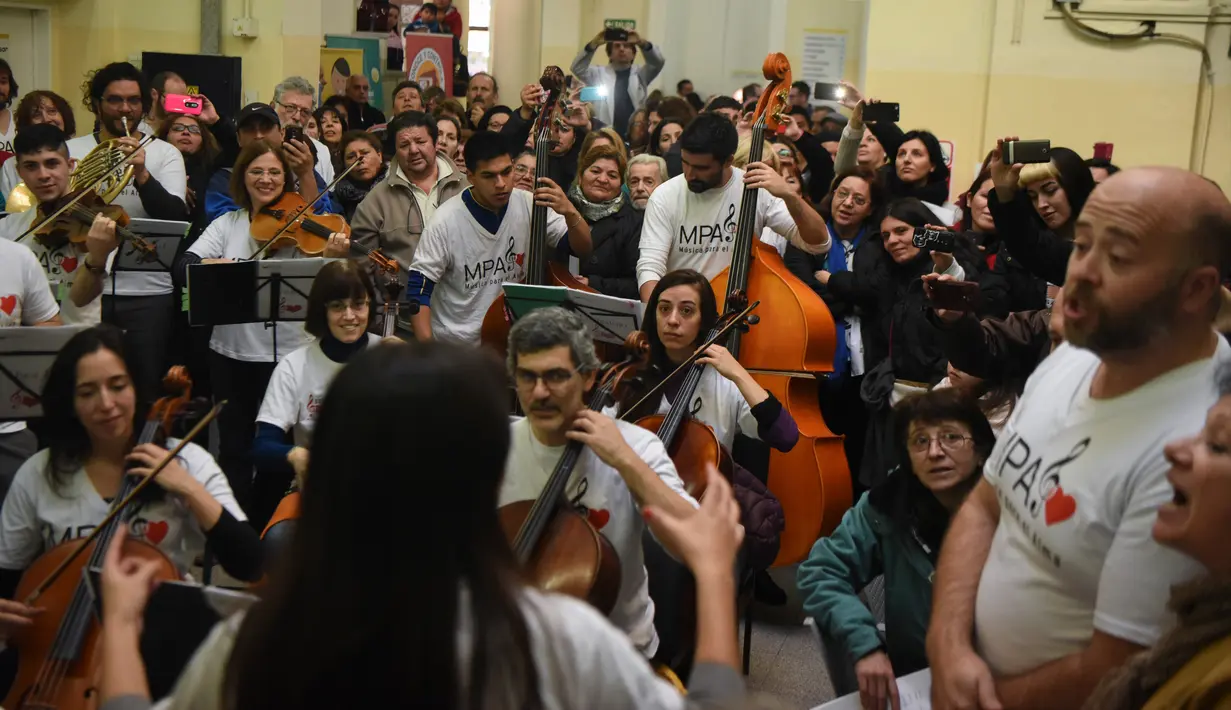 Relawan Musica Para el Alma tampil dalam konser flash mob di aula utama Rumah Sakit Alvarez di Buenos Aires, Argentina (12/6). Aksi para relawan itu pun menginspirasi lahirnya gerakan serupa di berbagai negara. (AFP Photo/Eitan Abramovich)