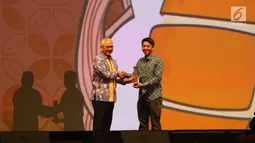 Deputi 4 Bidang Koordinasi Ekonomi Kreatif Kewirausahaan dan Daya Saing Koperasi dan Usaha Kecil Menengah Mohammad Rudy Salahuddin beri penghargaan juara partner Go-Food saat Malam Juara Go-Food 2018 di Jakarta, Jumat (23/2). (Liputan6.com/Angga Yuniar)