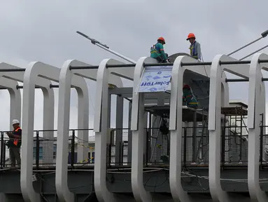 Pekerja melakukan pengerjaan revitalisasi Jembatan Penyeberangan Orang (JPO) Ratu Plaza, Jakarta, Jumat (28/12). JPO Ratu Plaza masuk dalam proses revitalisasi dan ditargetkan selesai pada akhir Desember 2018. (Liputan6.com/JohanTallo)