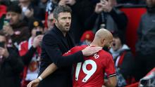Pelatih interim Manchester United, Michael Carrick, memberi ucapan selamat kepada gelandang asal Kamerun Bryan Mbeumo saat meninggalkan lapangan setelah ditarik keluar dalam pertandingan Liga Inggris antara Manchester United dan Manchester City di Old Trafford, Manchester, Sabtu (17/1/2026). (Darren Staples / AFP)