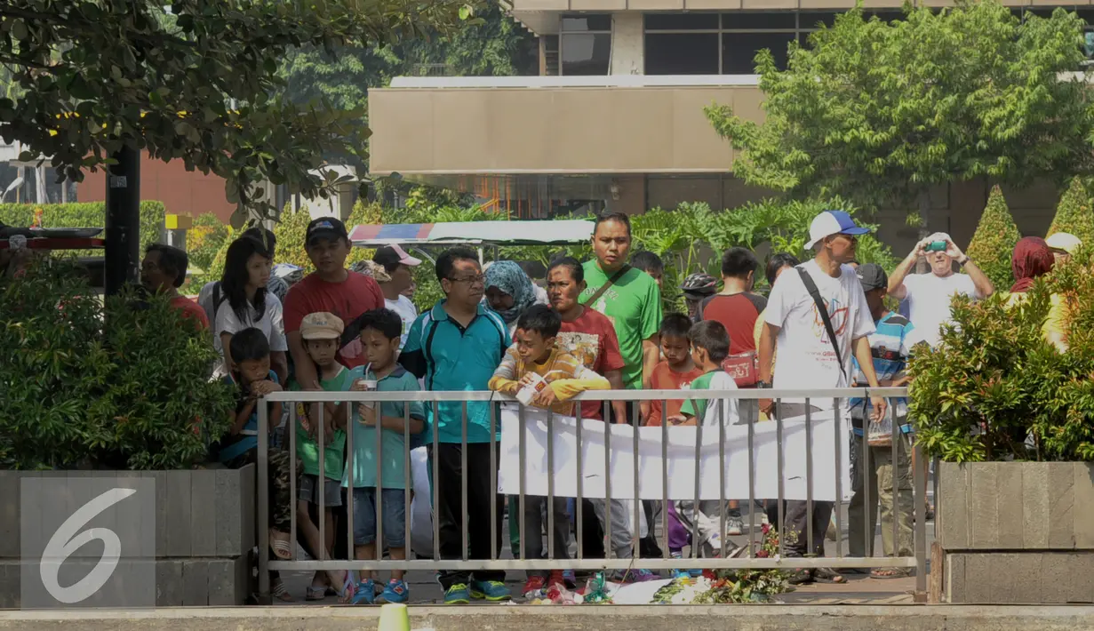Sejumlah warga mengajak keluarganya menyambangi lokasi ledakan di Kawasan Thamrin, Jakarta, Minggu (17/1/2016). Pasca Ledakan Thamrin, kegiatan Car Free Day tetap ramai seperti biasa. (Liputan6.com/Faisal R Syam)