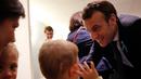 Presiden Prancis Emmanuel Macron berbicara dengan dengan anak-anak saat mengunjungi Graffiti's- Association Le Moulin Vert di Normandia, Prancis (5/4). (AP / Christophe Ena, Pool)