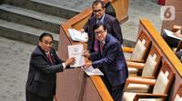 Ketua Komisi III DPR Bambang Wuryanto saat memberikan dokumen laporan Komisi III kepada Menteri Hukum dan HAM Yasonna Laoly saat rapat paripurna DPR di Jakarta, Selasa (6/12/2022). DPR RI resmi mengesahkan Rancangan Undang-Undang Kitab Undang-Undang Hukum Pidana (RUU KUHP) menjadi Undang-Undang. (Liputan6.com/Angga Yuniar)