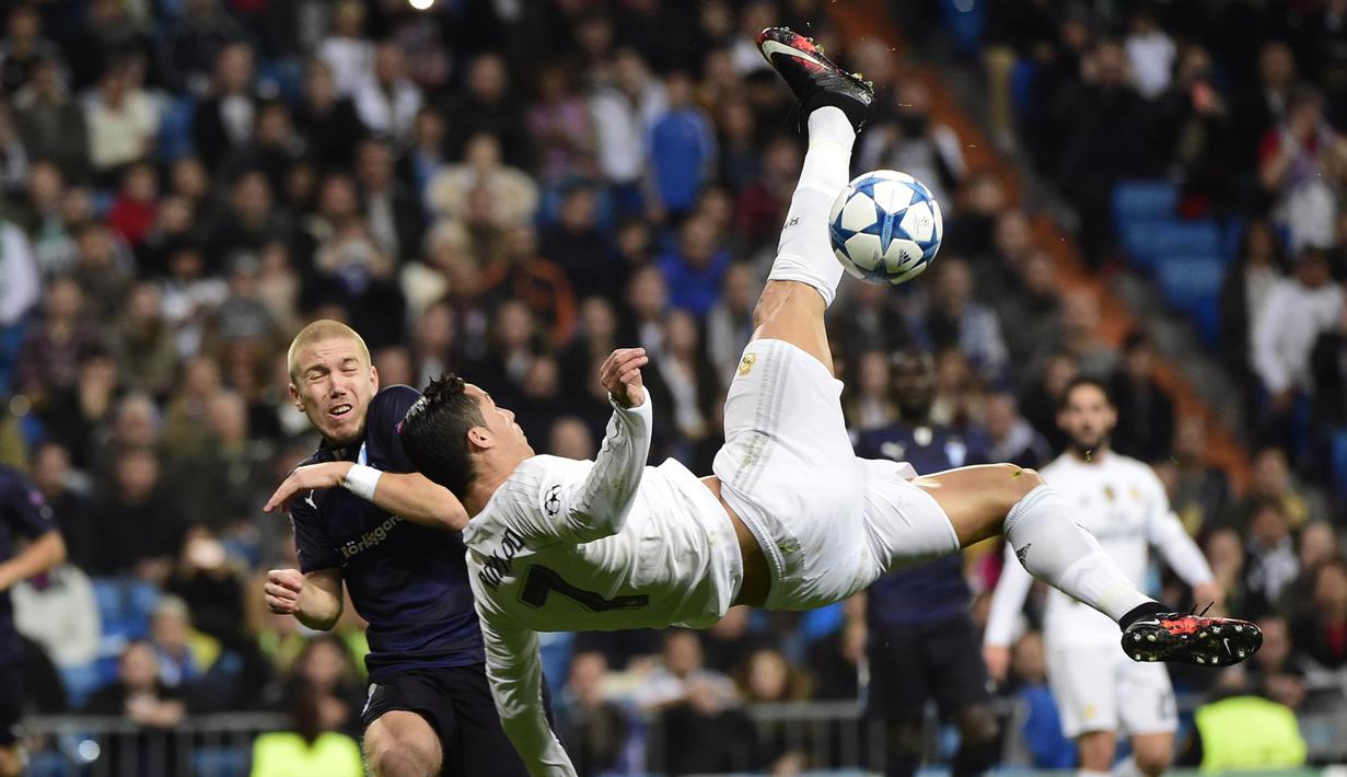 Pemain Real Madrid, Cristiano Ronaldo (kanan) melakukan tendangan salto melewaati pemain Malmo FF, Anton Tinnerholm  pada lanjutan Liga Champions Grup A di Stadion Satiago Bernabeu, Rabu (9/12/2015) dini hari WIB. (AFP Photo/ Pierre-Philippe Marcou)