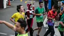 Peserta mengenakan kostum unik saat mengikuti lomba lari Milo Jakarta International 10K di kawasan Rasuna Epicentrum, Jakarta, Minggu (14/7/2019). Lomba ini digelar sebagai bagian dari perayaan Hari Ulang Tahun (HUT)  ke-492 DKI Jakarta. (Liputan6.com/Faizal Fanani)