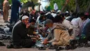 Orang-orang yang membutuhkan makan makanan yang disediakan oleh para donor amal di Islamabad, Pakistan pada tanggal 2 Mei 2023. (Photo by Aamir QURESHI / AFP)