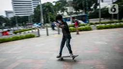 Aksi warga saat bermain skateboard di trotoar Jalan Sudirman-Thamrin, Jakarta, Jumat (5/3/2021). Gubernur DKI Jakarta Anies Baswedan mengizinkan trotoar untuk digunakan sebagai tempat bermain skateboard dengan beberapa kesepakatan. (Liputan6.com/Faizal Fanani)