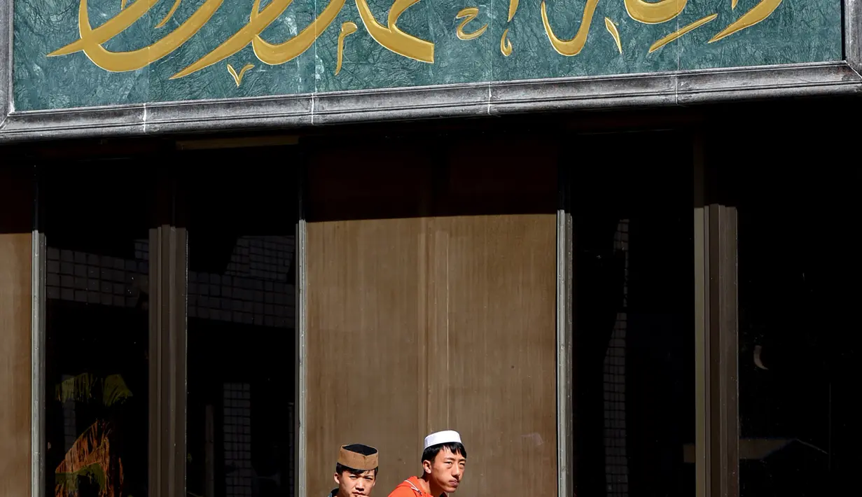 Dua mahasiswa China Hui Muslim berjalan masuk ke kelas di Institut Islam di Yinchuan Ningxia, Provinsi Ningxia utara China (22/9/2015). Kampus ini memiliki slogan "Cinta negara, cinta agama" yang terpampang di pintu masuk. (AFP PHOTO/GOH CHAI HIN)