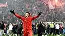 Suporter Olympiakos turun ke lapangan merayakan kemenangan atas AC Milan pada laga Europa di Stadion Georgios Karaiskakis, Athena, Kamis (13/12). Olympiakos menang 3-1 atas AC Milan. (AFP/Aris Messinis)