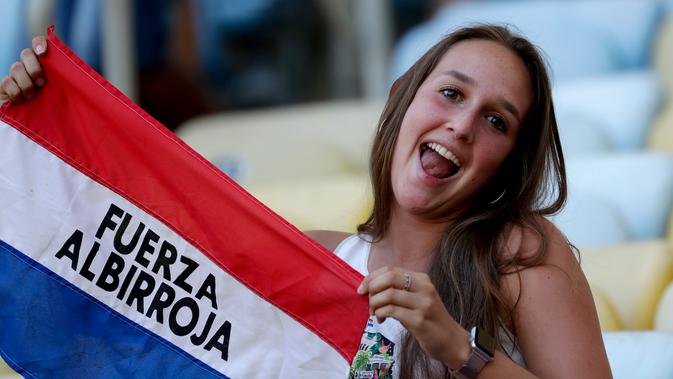 Seorang suporter menunjukkan bendera Paraguay saat negara tersebut akan bertanding dalam laga Grup B Copa America 2019 di Stadion Maracana, Rio de Janeiro, Brasil, Minggu (16/6/2019). (AP Photo/Silvia Izquierdo)