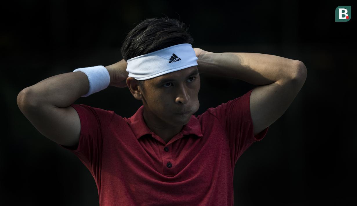 Petenis Indonesia, Christopher Rungkat, memasang ikat kepala saat latihan di Lapangan Tenis Pondok Indah, Jakarta, Kamis (19/7/2018). Dirinya merupakan salah satu petenis yang akan turun pada Asian Games XVIII. (Bola.com/Vitalis Yogi Trisna)