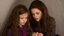 Ini saat Bella memperlihatkan foto keluarganya pada Renesmee yang terpampang di kalungnya. (Cosmopolitan)
