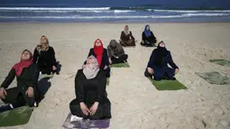 Sejumlah wanita Palestina berlatih yoga di pantai di Gaza City (3/3/2020). Pelatihan yoga tersebut diselenggarakan oleh Positive Energy Club. (AFP Photo/Mohammed Abed)