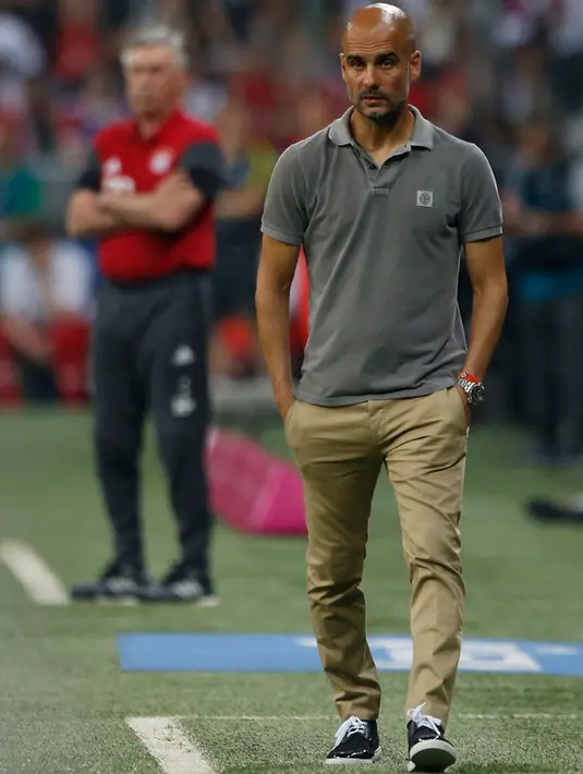 Pelatih baru Manchester City, Pep Guardiola terlihat lesu saat timnya tunduk atas Manchester City di laga pramusim di Allianz Arena, Muenchen (21/7). Ini menjadi pertandingan debut Pep Guardiola sebagai manajer The Citizens. (Reuters/Michaela Rehle)