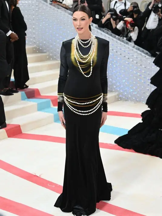 Karlie Kloss mengumumkan kehamilan anak ke-2 di red carpet Met Gala. Ia mengekspos baby bumpnya dengan dress hitam dengan detail gold dari Loewe. [@themetgalaofficial]