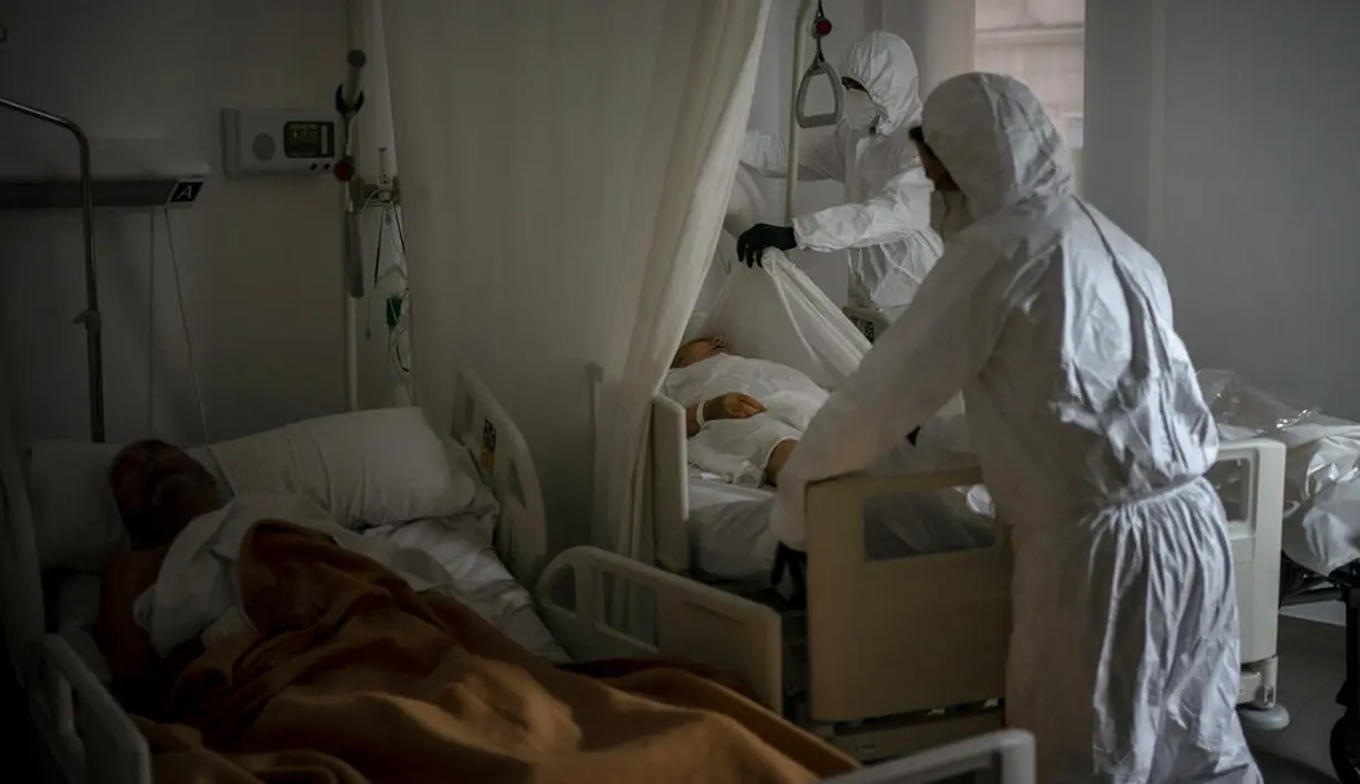 Petugas kamar jenazah mengenakan APD saat mengurus jenazah lansia yang meninggal karena COVID-19 di sebuah panti jompo, Barcelona, Spanyol, 5 November 2020. Seperti dokter dan perawat, petugas kamar jenazah adalah bagian dari sekelompok pekerja penting di tengah pandemi. (AP Photo/Emilio Morenatti)