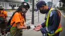 Relawan yang tergabung dalam Gerakan Jaga Indonesia aksi memyemprotkan hand sanitizer kepada pengguna jalan di Pelican Cross kawasan Thamrin, Jakarta, Senin (23/3/2020). Aksi tersebut mengajak masyarakat menjaga kebersihan tangan untuk mengurangi penyebaran Covid-19. (Liputan6.com/Faizal Fanani)