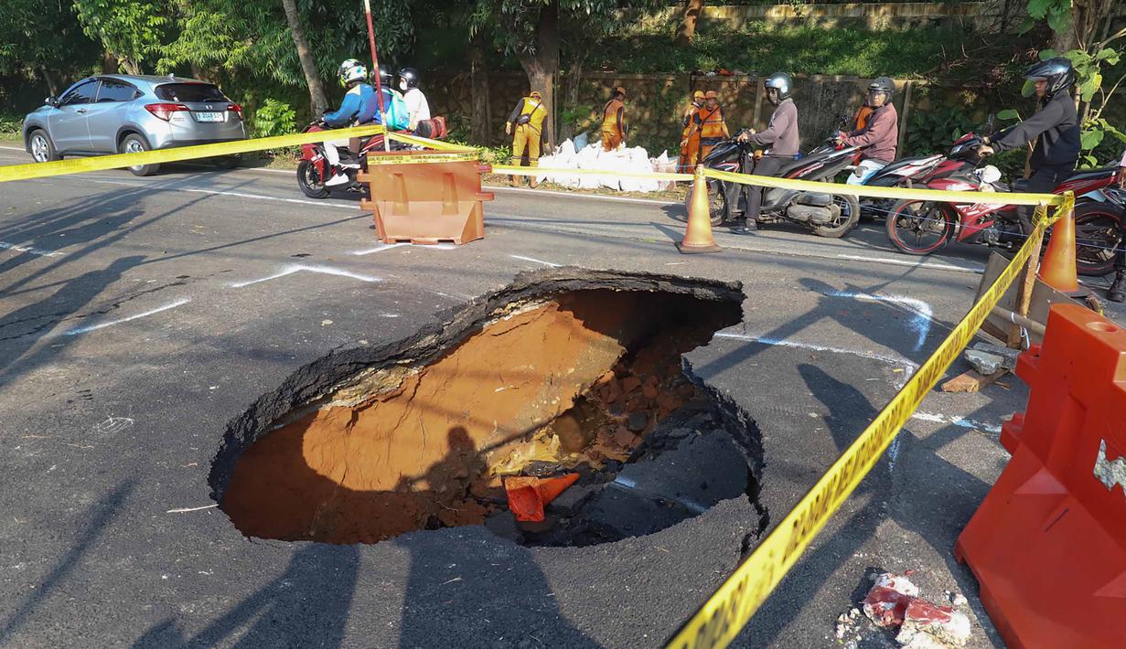 Pengendara melintas di sisi ruas jalan yang ditutup sebagian akibat amblas di Jalan Raya Lenteng Agung, Jakarta Selatan, Jumat (29/5/2026). (merdeka.com/Arie Basuki)