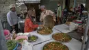 Sekretaris Masjid Bang Aw, Adul Yothasmutr (kiri) menyaksikan sukarelawan menyiapkan makanan di Bangkok, Thailand, Kamis (30/4/2020). Setiap hari selama Ramadan, sukarelawan membagikan makanan kepada 150 keluarga sekitar Masjid Bang Aw. (AP Photo/Gemunu Amarasinghe)