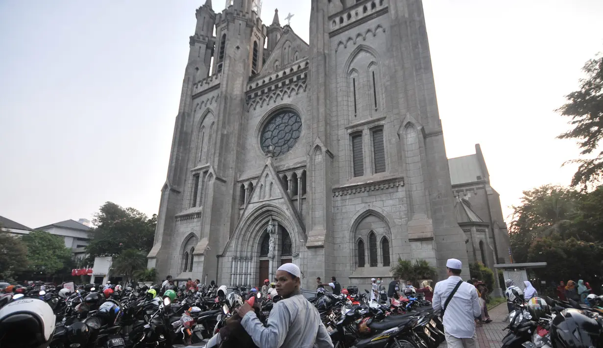 Umat muslim yang akan menunaikan salat Idul Adha di Masjid Istiqlal memarkirkan kendaraan mereka di halaman Gereja Katedral, Jakarta, Minggu (11/8/2019). Untuk membantu jemaah melaksanakan ibadah, Katedral menyediakan lahan parkirnya dan mengundurkan waktu ibadah Misa. (merdeka.com/Iqbal S Nugroho)