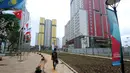 Pewarta melintas di sekitar taman wisma atlet Asian Games 2018, Kemayoran, Jakarta, Minggu (4/2). Pembangunan rusun yang akan digunakan sebagai Wisma Atlet pada Asian Games 2018 telah dinyatakan selesai 100 persen. (Liputan6.com/Helmi Fithriansyah)
