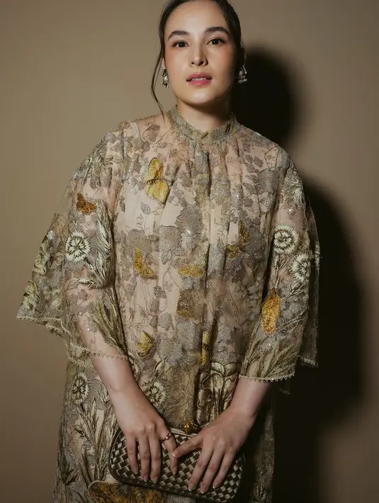 Melengkapi tampilannya dengan membawa clutch coklat dari Bottega Veneta seharga Rp13 juta  [@biyanofficial]