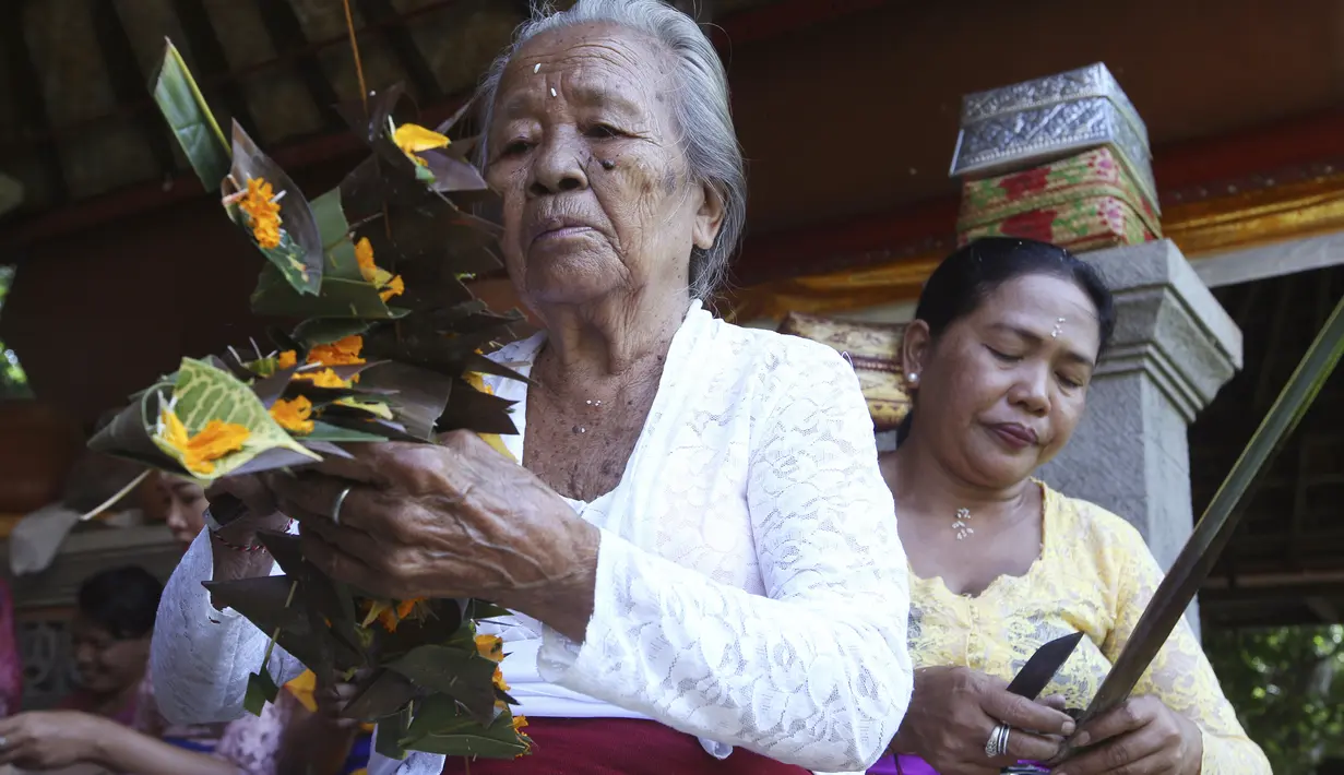  Warga Bali mendekorasi bunga yang akan menjadi penghias kuil Hindu di dekat lokasi yang akan dikembangkan menjadi resor bintang enam yang dikelola oleh Trump Organization di Beraban, Bali, Rabu (12 /4). (AP Photo)