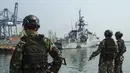 Tiga personel Korps Marinir Indonesia menyambut kedatangan Kapal Perang Kerajaan Inggris His Majesty’s Ship (HMS) Tamar di Pelabuhan Tanjung Priok, Jakarta pada Rabu 17 Juni 2026. (BAY ISMOYO/AFP)