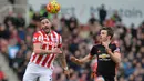 Bek Stoke, Geoff Cameron, duel udara dengan Kapten Manchester United, Michael Carrick, pada liga Premier League. (AFP/Paul Ellis)