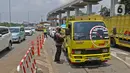 Petugas memeriksa kendaraan yang memasuki Jakarta pada penerapan PSBB di gerbang pintu Tol Pasar Rebo 2, Jakarta, Jumat (10/4/2020).  Petugas juga mengimbau agar menjaga jarak untuk menghindari penularan COVID-19 sesuai Peraturan Menteri Kesehatan Nomor 9 tahun 2020. (Liputan6.com/Herman Zakharia)