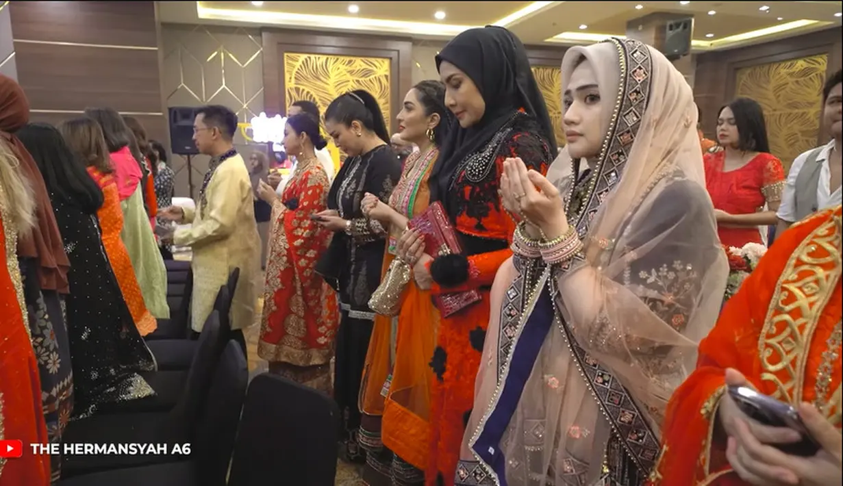 Para tamu undangan kompak mengenakan outfit India. Mereka berdiri sejenak untuk berdoa bersama di pimpin oleh ustaz. [Youtube/The Hermansyah A6]