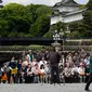 Wisatawan foto bersama di area Taman Istana Kekaisaran di Tokyo, Jepang (29/4/2019). Kaisar Jepang Akihito akan turun dari Tahta Krisan pada 30 April 2019 mengakhiri 30 tahun masa pemerintahannya. (Kazuhiro NOGI / AFP)