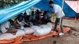 Warga korban gempa saat menerima bantuan di tenda pengungsian Pasaman Barat, Sumatera Barat, Jumat (26/2/2022). BRI terus bersinergi dengan pemerintah setempat dan Badan Usaha Milik Negara (BUMN) untuk bahu membahu membantu meringankan beban masyarakat yang terdampak gempa.(Liputan6.com/HO/CSR BRI)