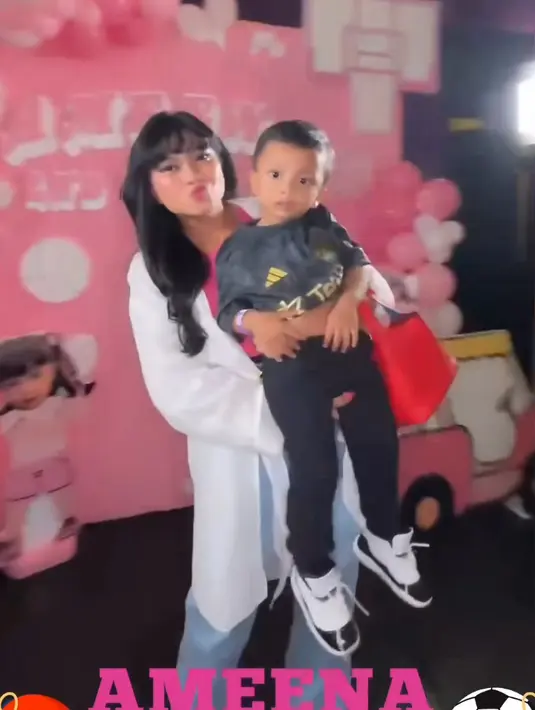 Hanum Mega tampil mengenakan kemeja putih panjang sebagai outer dipadukan tanktop pink dan celana denim. [@real.hanummegaa]