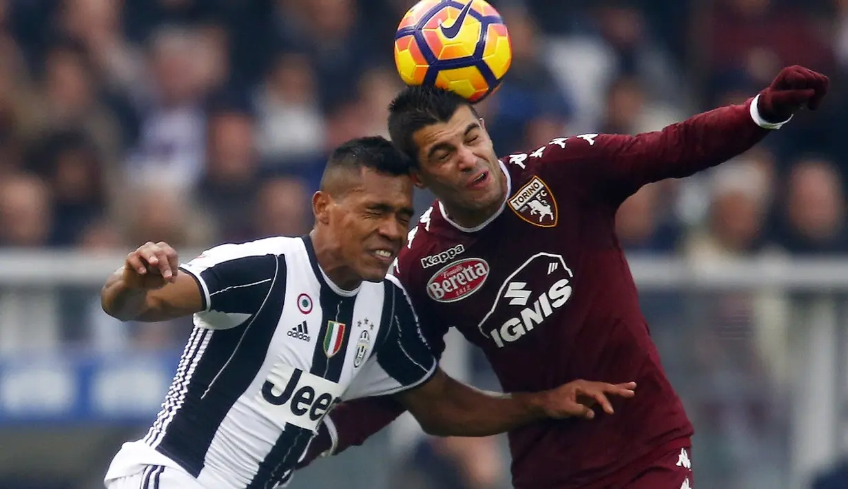 Gelandang Juventus, Juan Cuadrado, berebut bola dengan gelandang Torino, Daniele Baselli, dalam laga pekan ke-16 Serie A 2016-2017 di Stadion Olimpico Grande Torino, Minggu (11/12/2016). (AFP/Marco Bertorello)