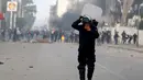 Polisi anti huru hara terkena gas air mata yang dilemparkan rekannya untuk membubarkan demonstrasi di Kasserine, Tunisia, Kamis (21/1). Para pengangguran muda menuntut solusi dari masalah pengangguran yang meliputi negaranya. (REUTERS/Amine Ben Aziza)