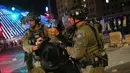 Petugas polisi Israel membubarkan pria Yahudi ultra-Ortodoks yang menghalangi jalan dalam aksi protes menentang rencana wajib militer mereka di militer Israel, di Yerusalem, Kamis 30 Oktober 2025. Setelah beberapa jam, polisi menggunakan meriam air untuk membubarkan para demonstran. (AP Photo/Ohad Zwigenberg)