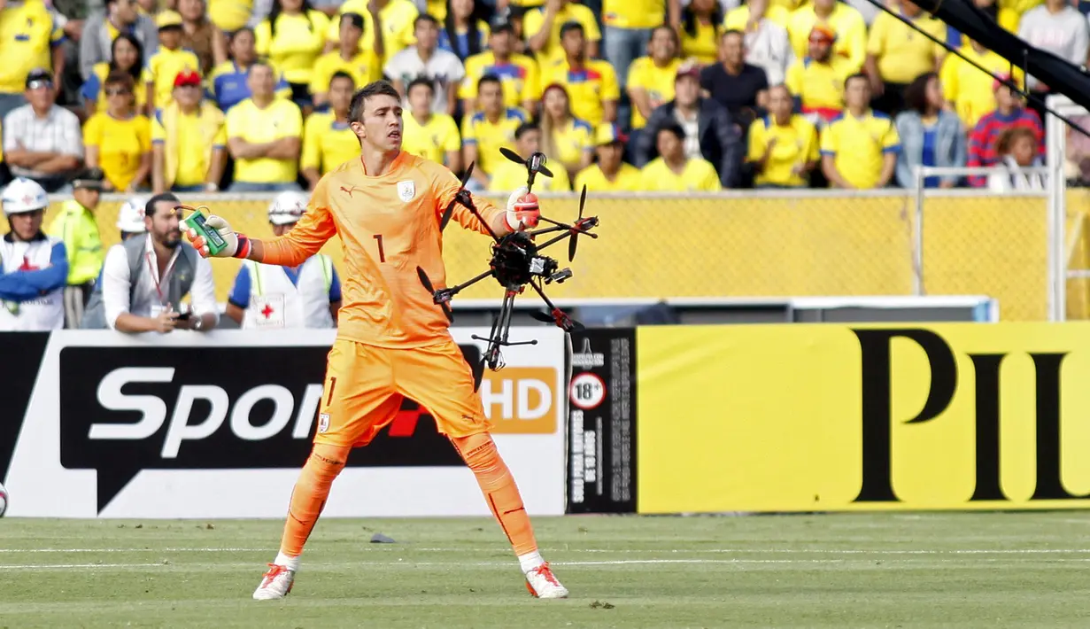 Kiper Uruguay, Fernando Muslera, mengambil drone yang terjatuh ke dalam lapangan saat pertandingan melawan Ekuador dalam Kualifikasi Piala Dunia 2018 di Stadion Atahualpa, Quito, Ekuador, (12/11/2015). (Reuters/Gary Granja)